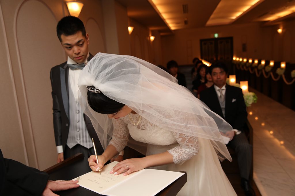 結婚証明書にサインをする新婦