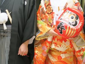 だるまを持つ新郎新婦